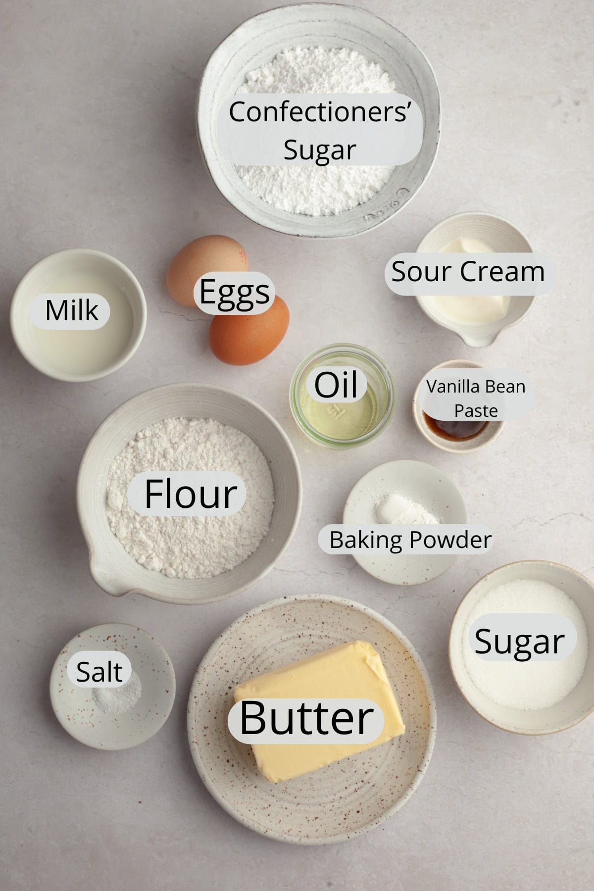 All the ingredients needed to make vanilla bean cupcakes, weighed out into small bowls.