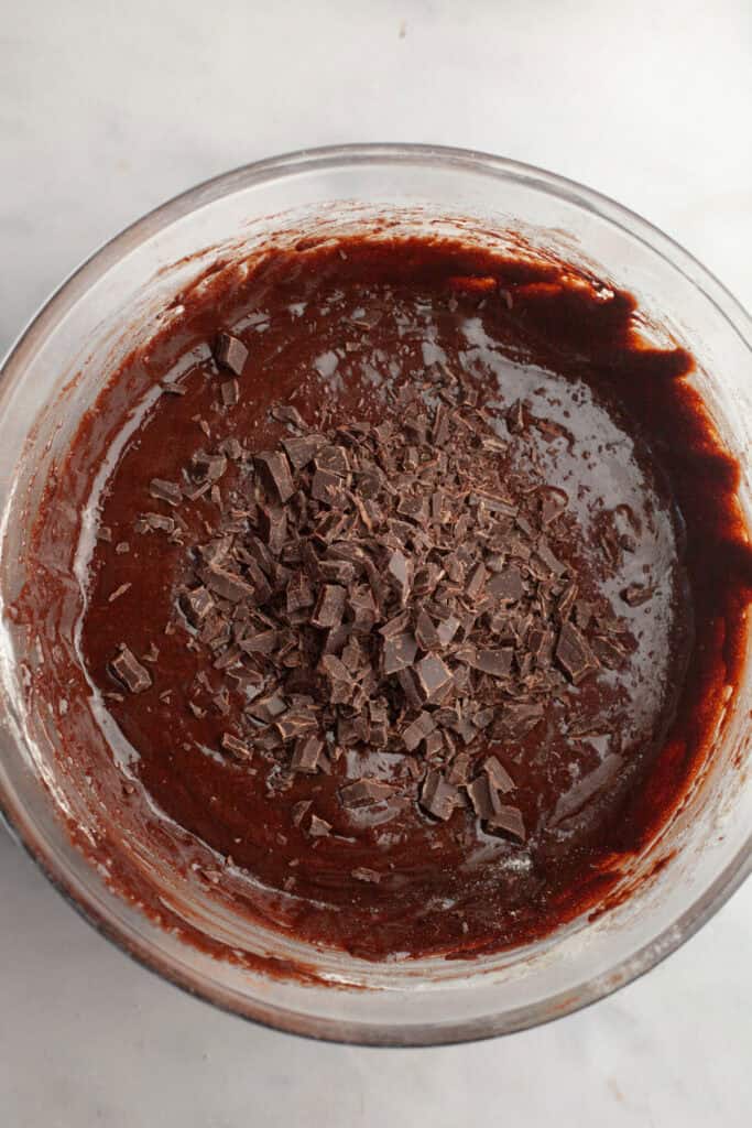 A bowl with brownie batter and chopped chocolate.