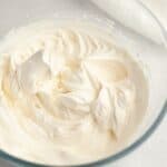 A glass bowl with vanilla bean whipped cream.