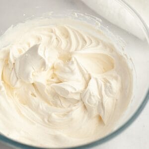 A glass bowl with vanilla bean whipped cream.