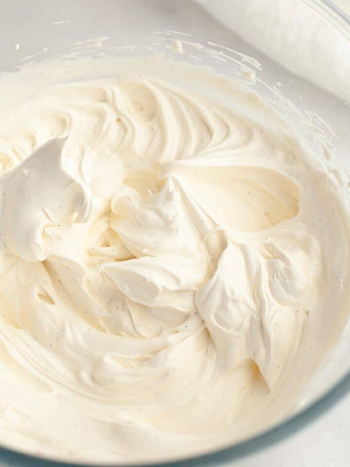 A glass bowl with vanilla bean whipped cream.