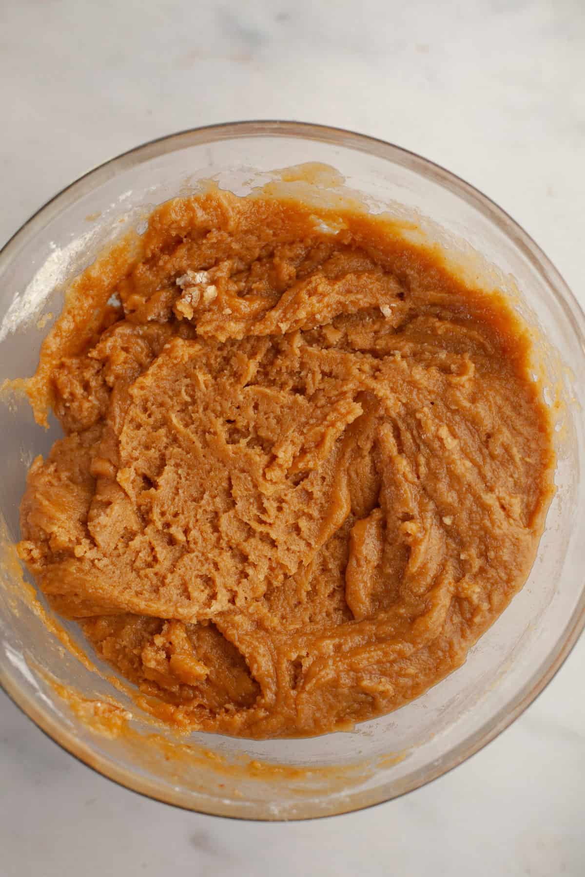 Peanut butter cookie dough in a glass bowl.