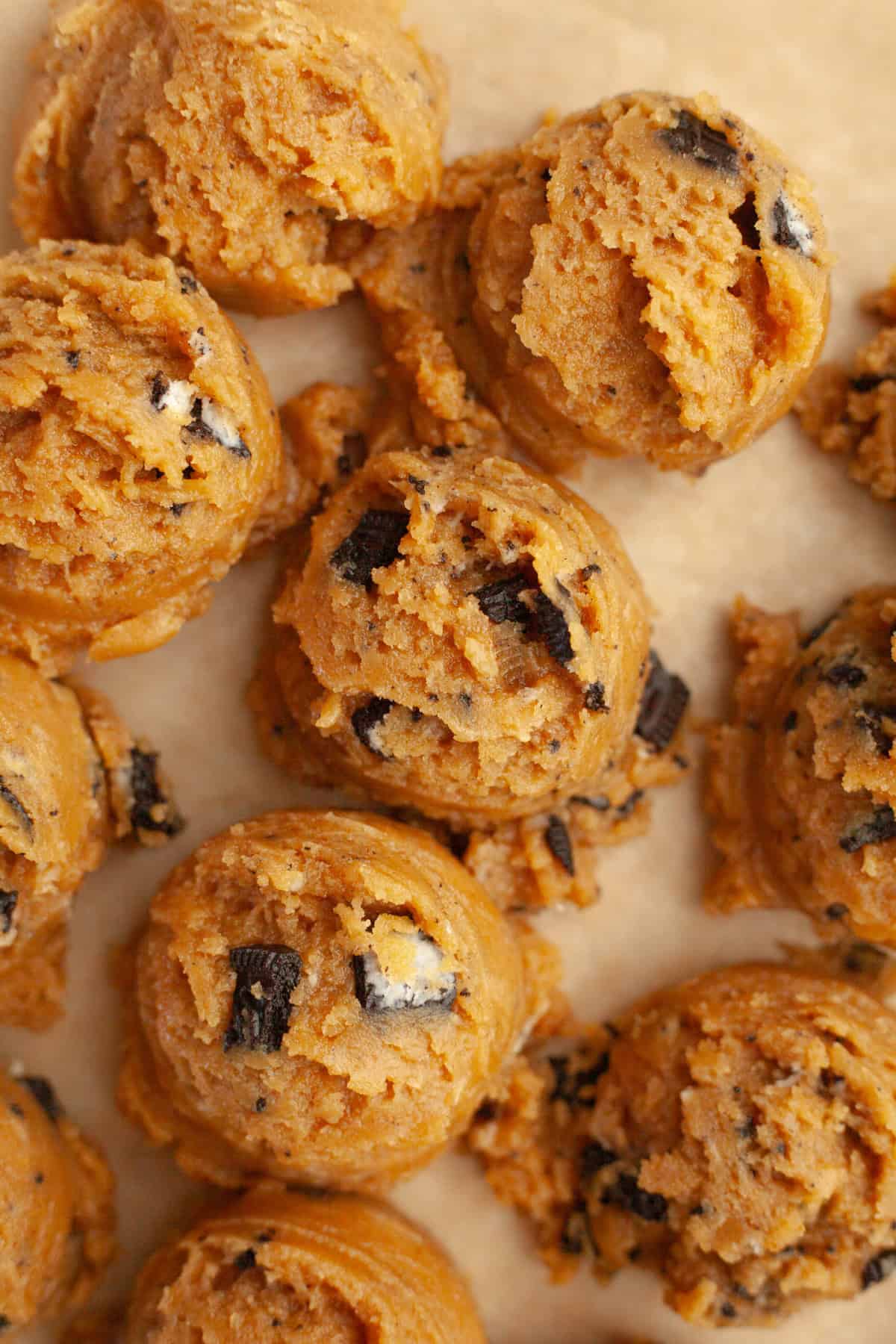 Peanut butter Oreo cookie dough balls on parchment paper.
