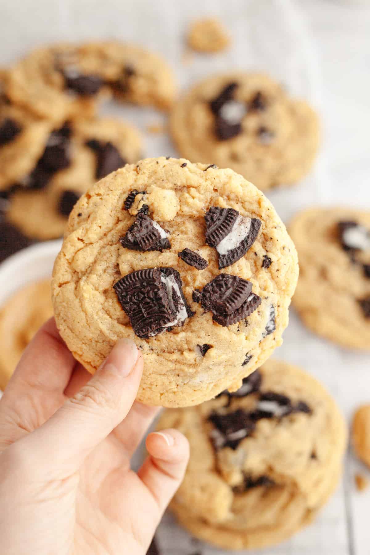 A hand holding an Oreo peanut butter brown butter cookie.