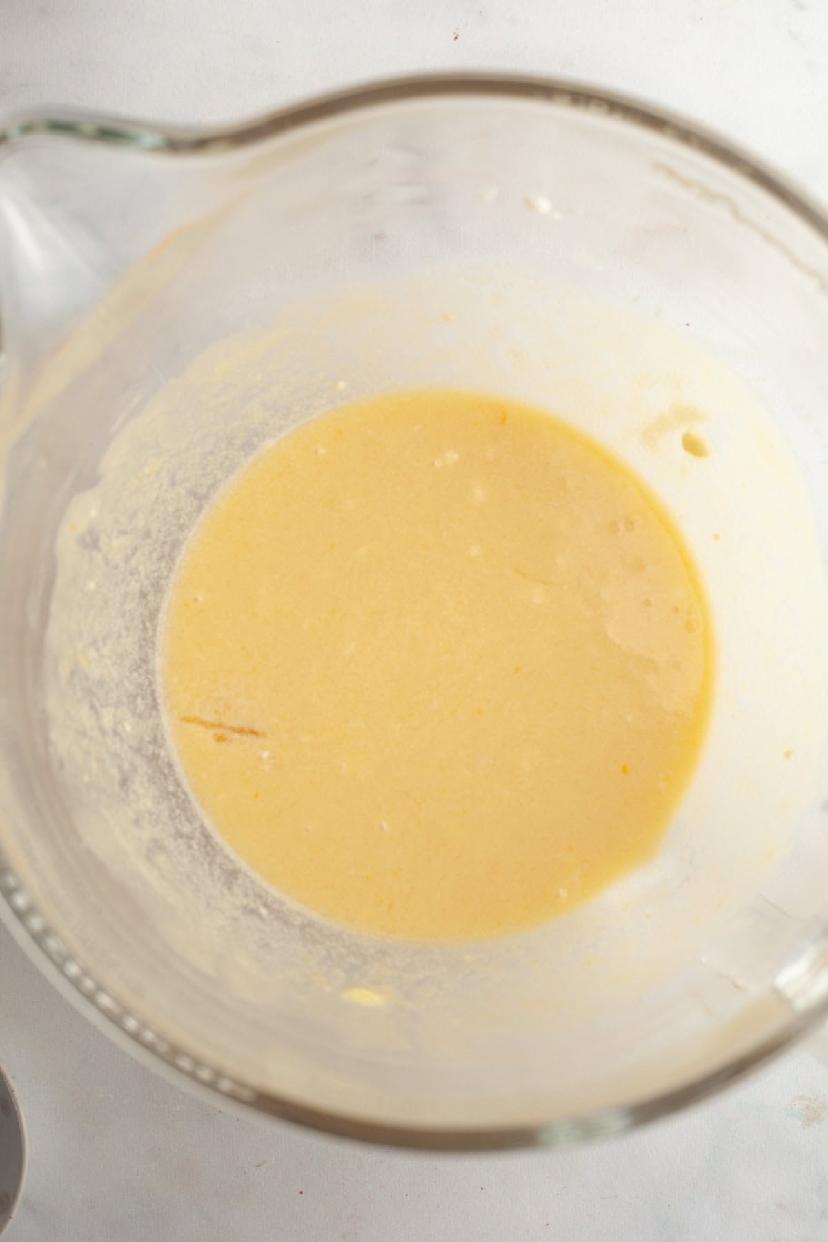 A glass bowl with a yellow liquid in it.