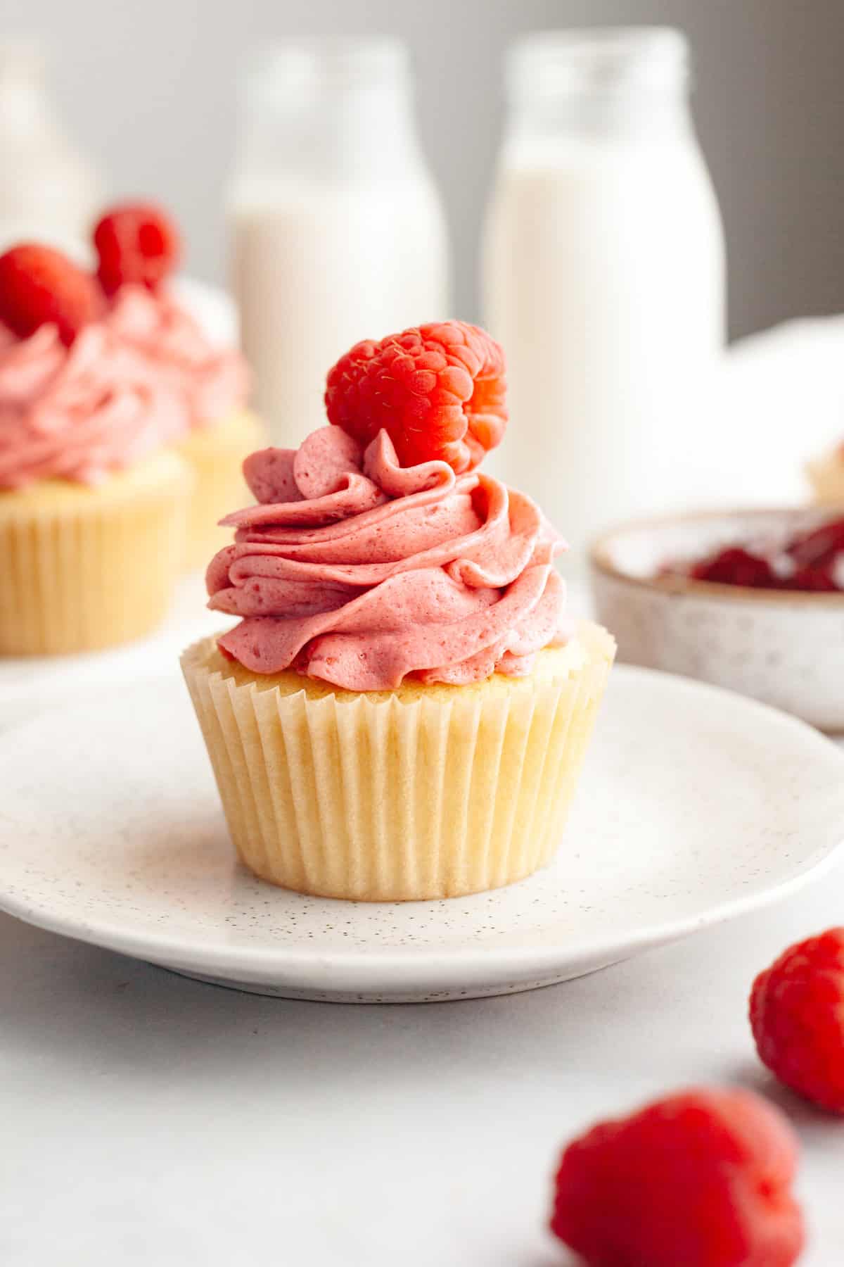 A raspberry almond cupcake on a small plate.