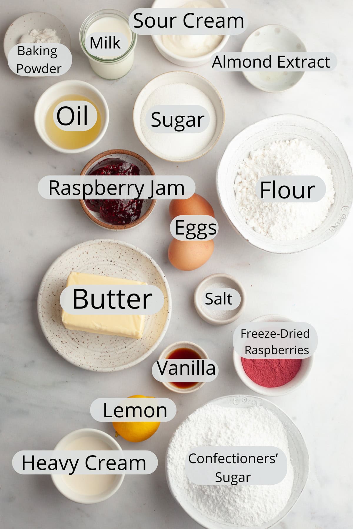 All the ingredients needed to make raspberry almond cupcakes, weighed out into small bowls.