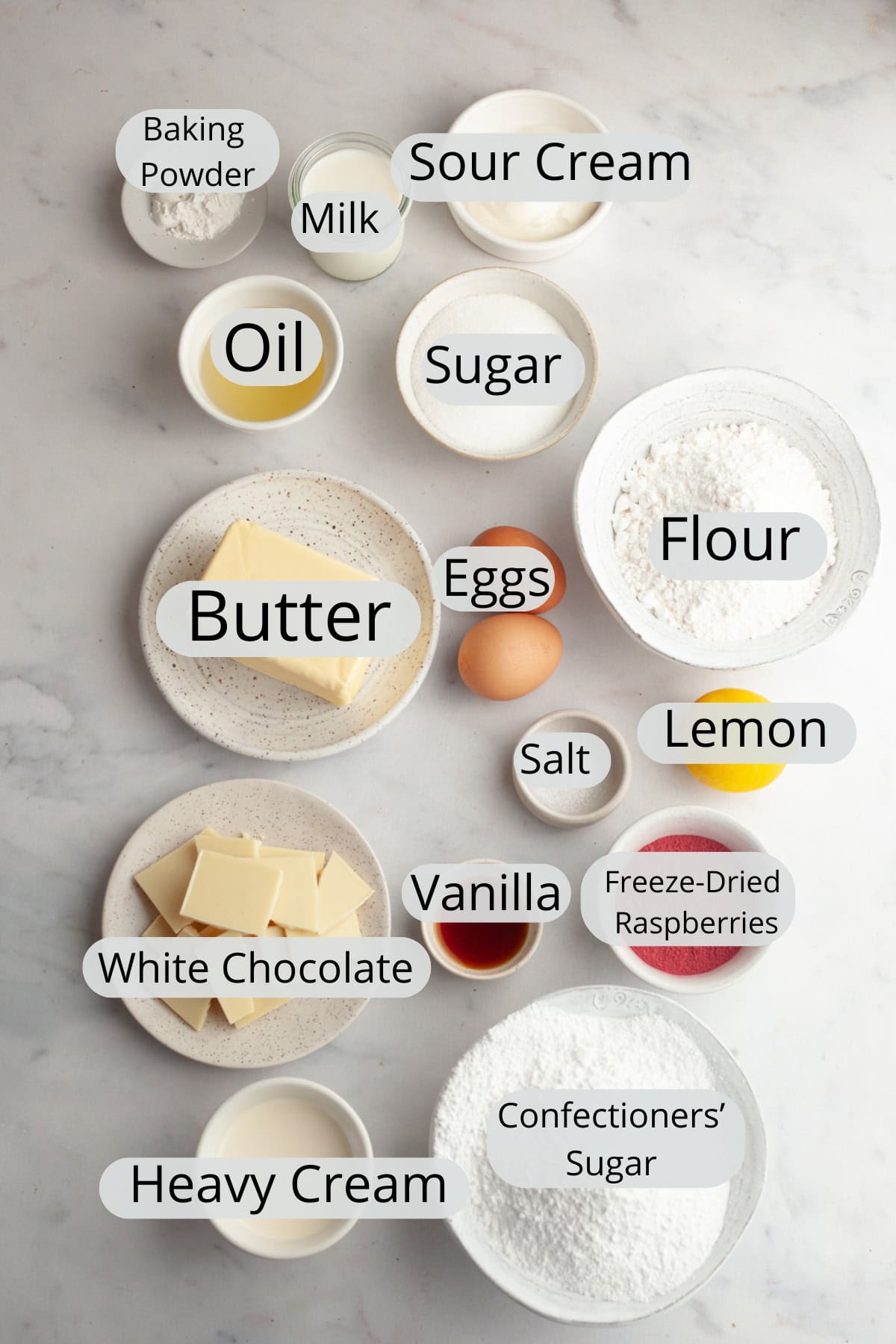 All the ingredients needed to make raspberry white chocolate cupcakes, weighed out into small bowls.