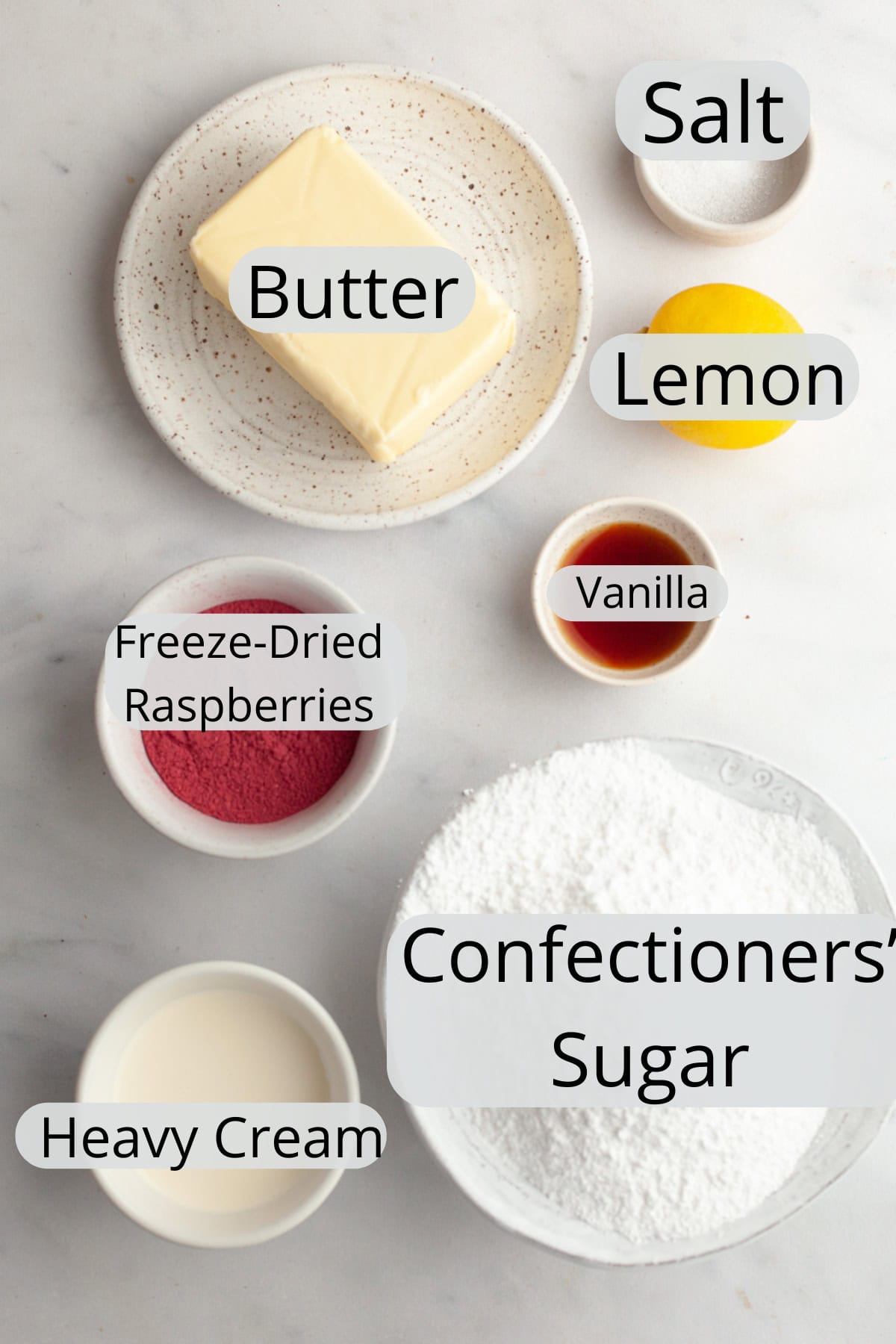 All the ingredients needed to make raspberry buttercream, weighed out into small bowls.