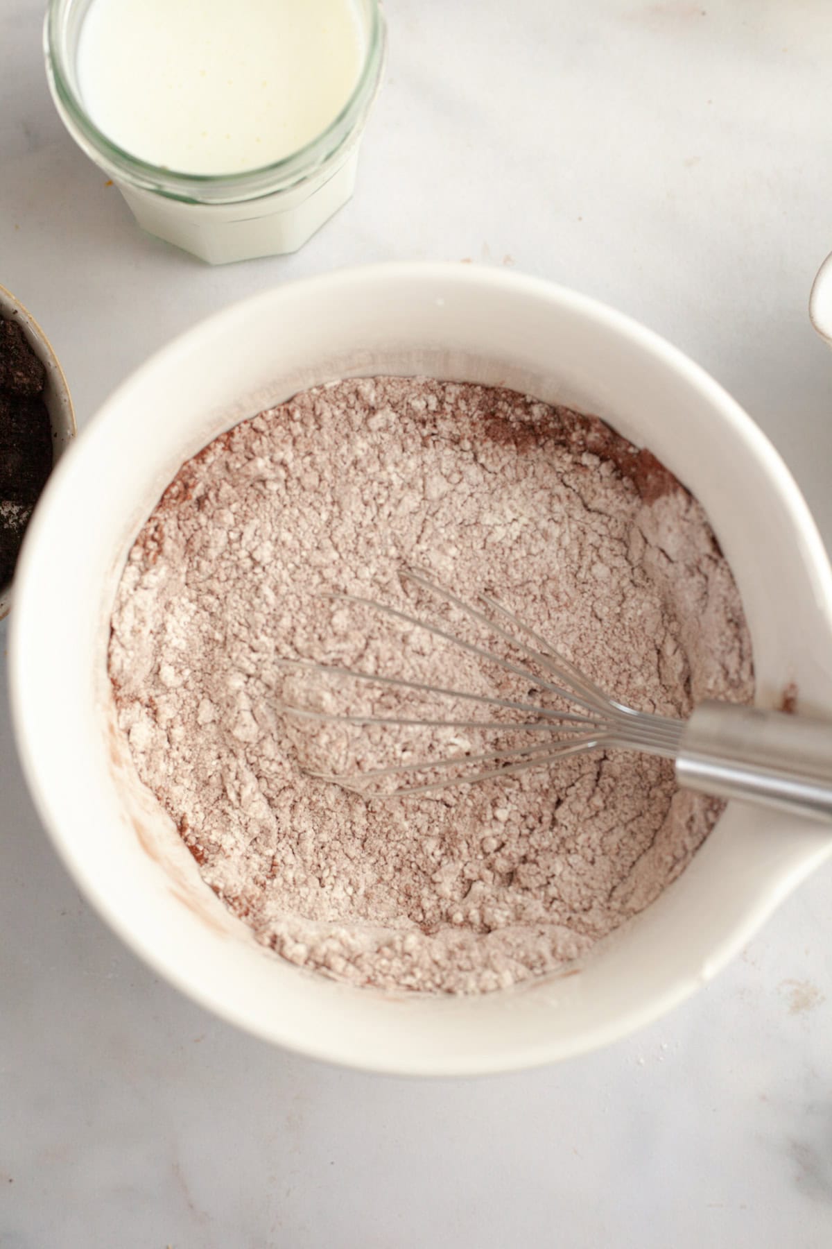 A white bowl with flour and cocoa powder in it.