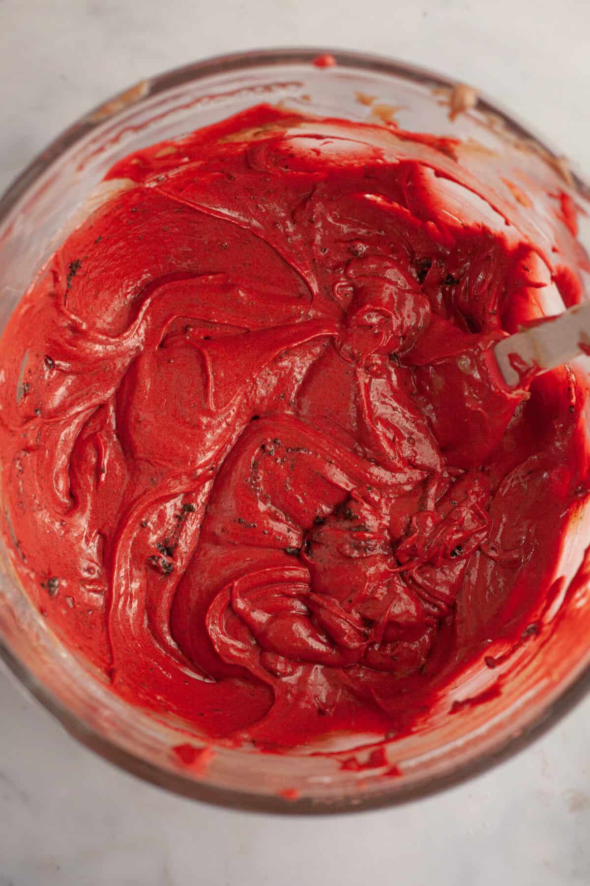 Red velvet cake batter with Oreo crumbs in a glass bowl.