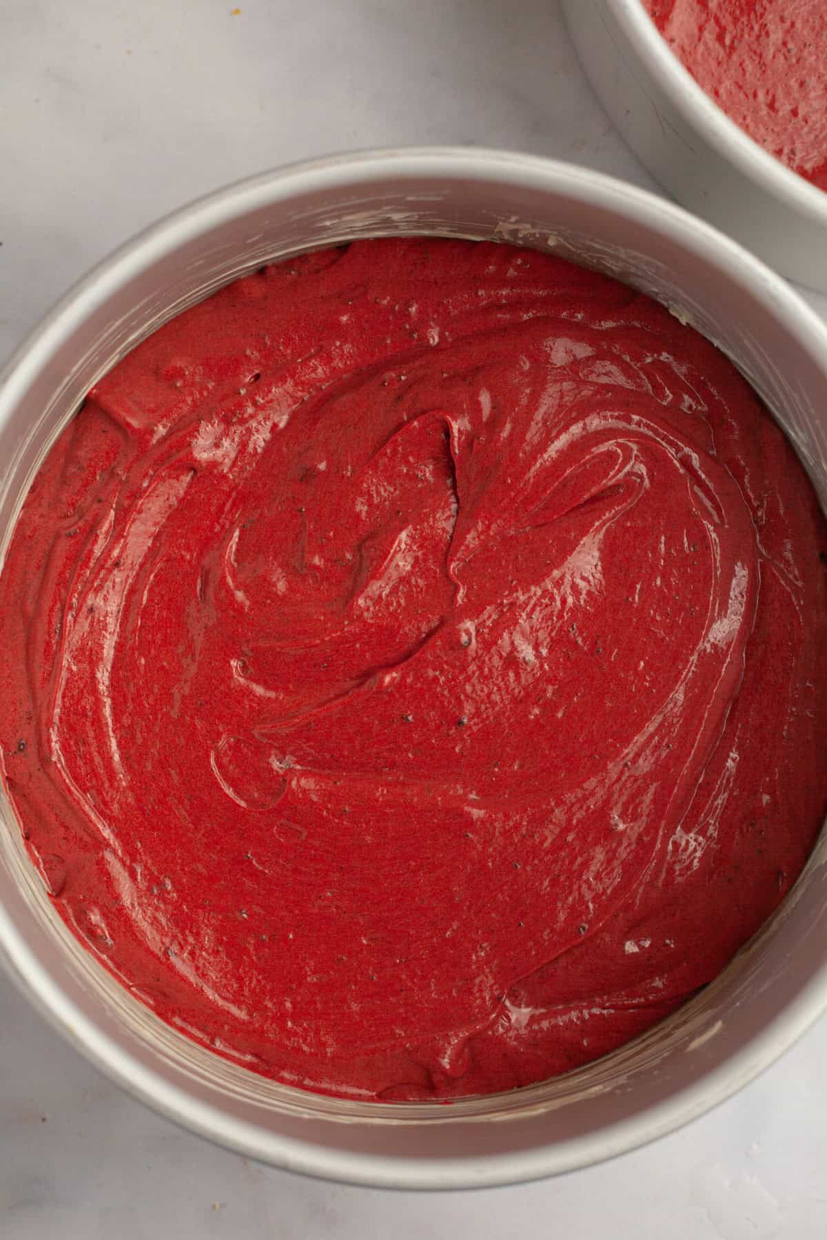 Unbaked red velvet Oreo cake in round cake pans.