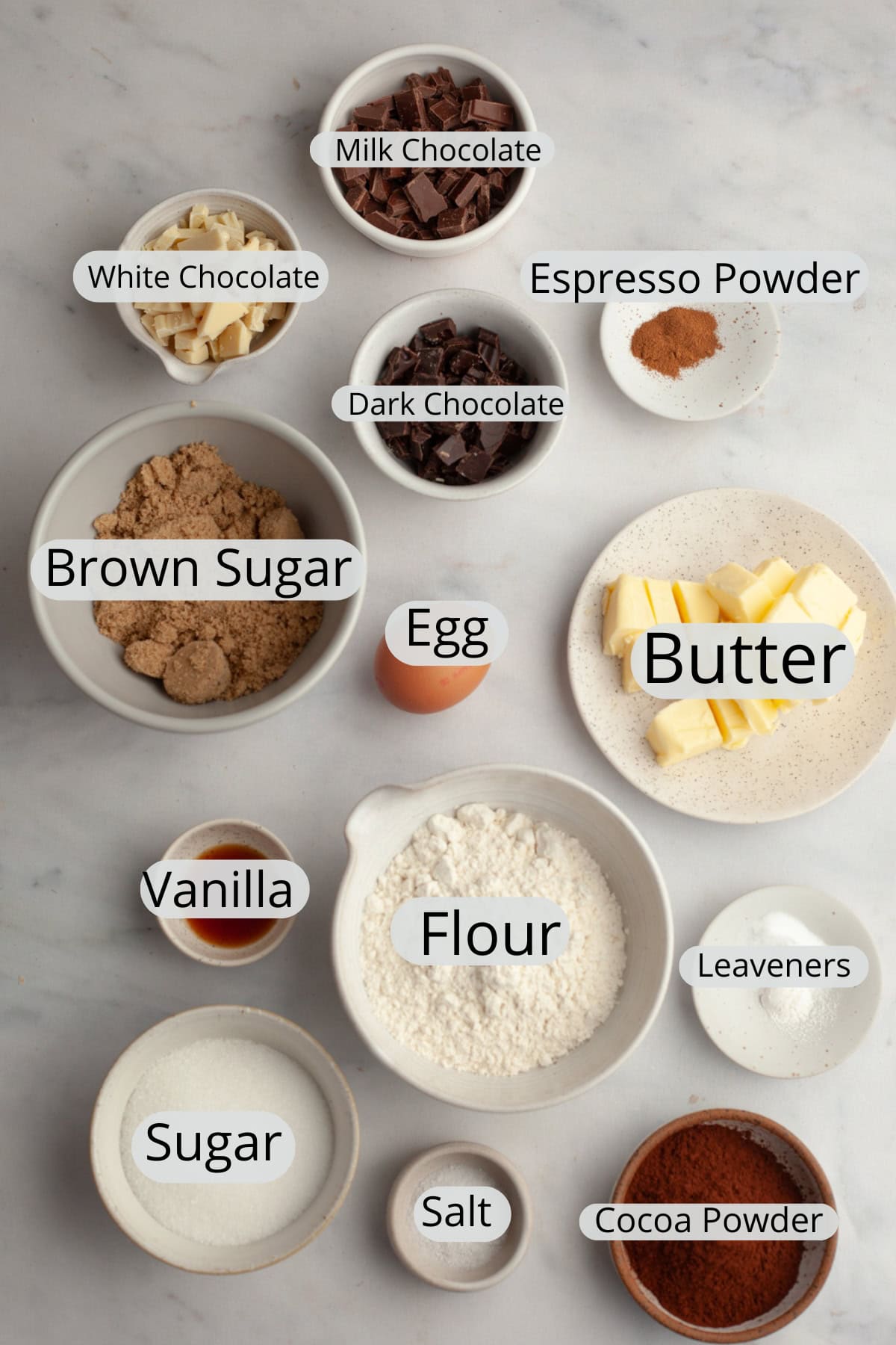 All the ingredients needed to make triple chocolate chunk cookies, weighed out into small bowls.