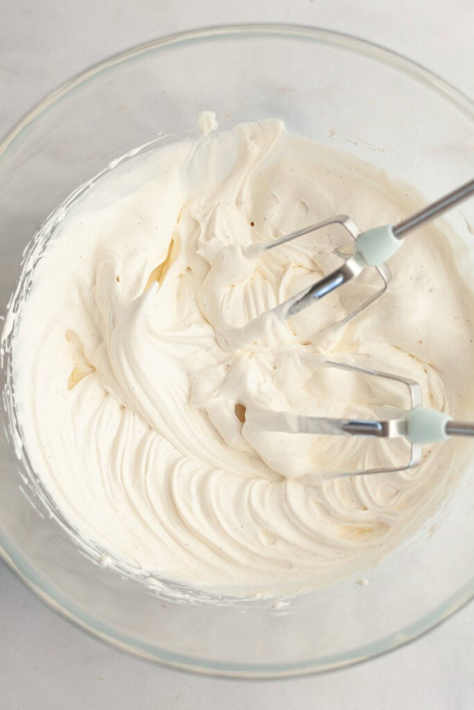A glass bowl with vanilla bean whipped cream.