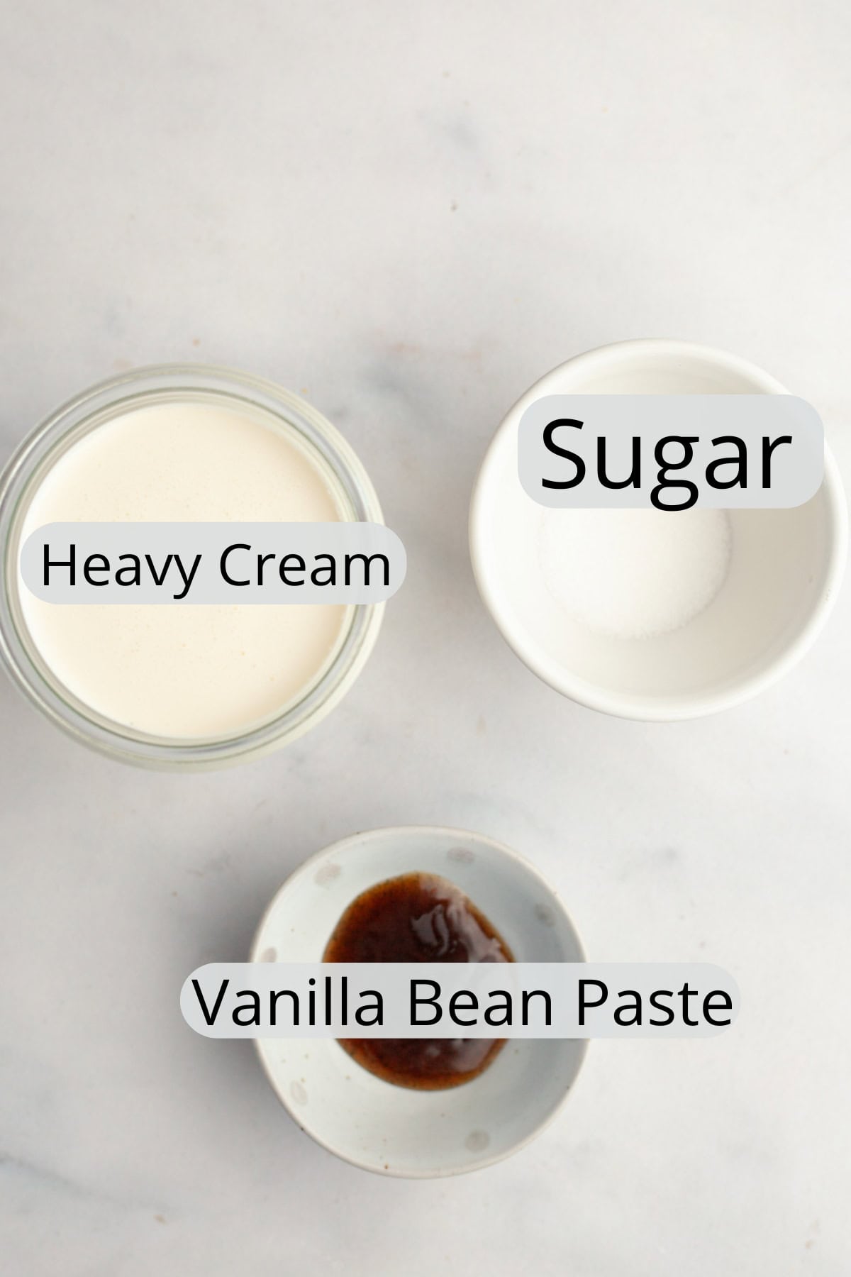 All the ingredients needed to make vanilla bean whipped cream, weighed out into small bowls.