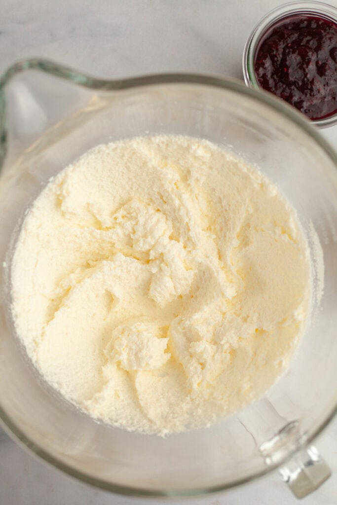 A large glass mixing bowl with creamed butter and sugar in it.