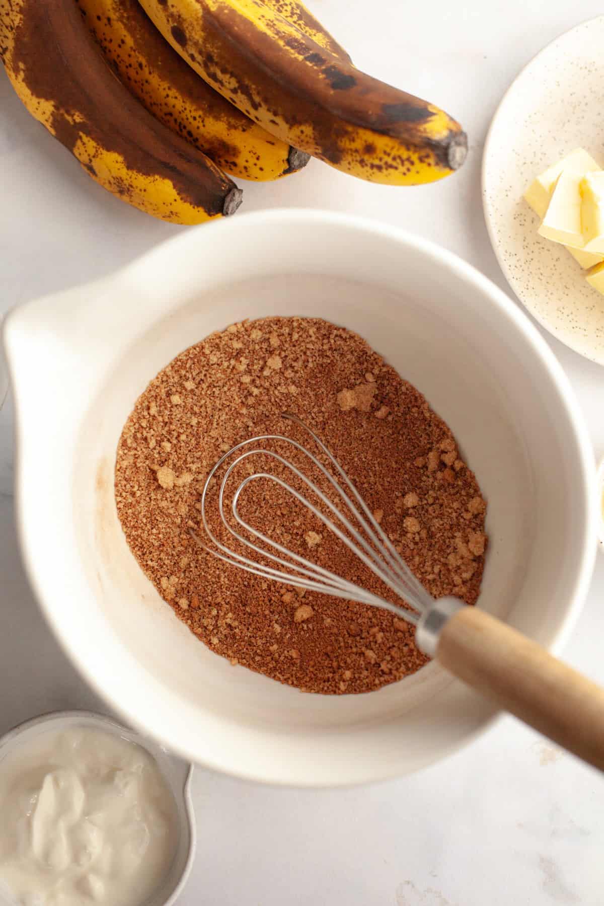 A large white bowl with cinnamon and brown sugar in it.