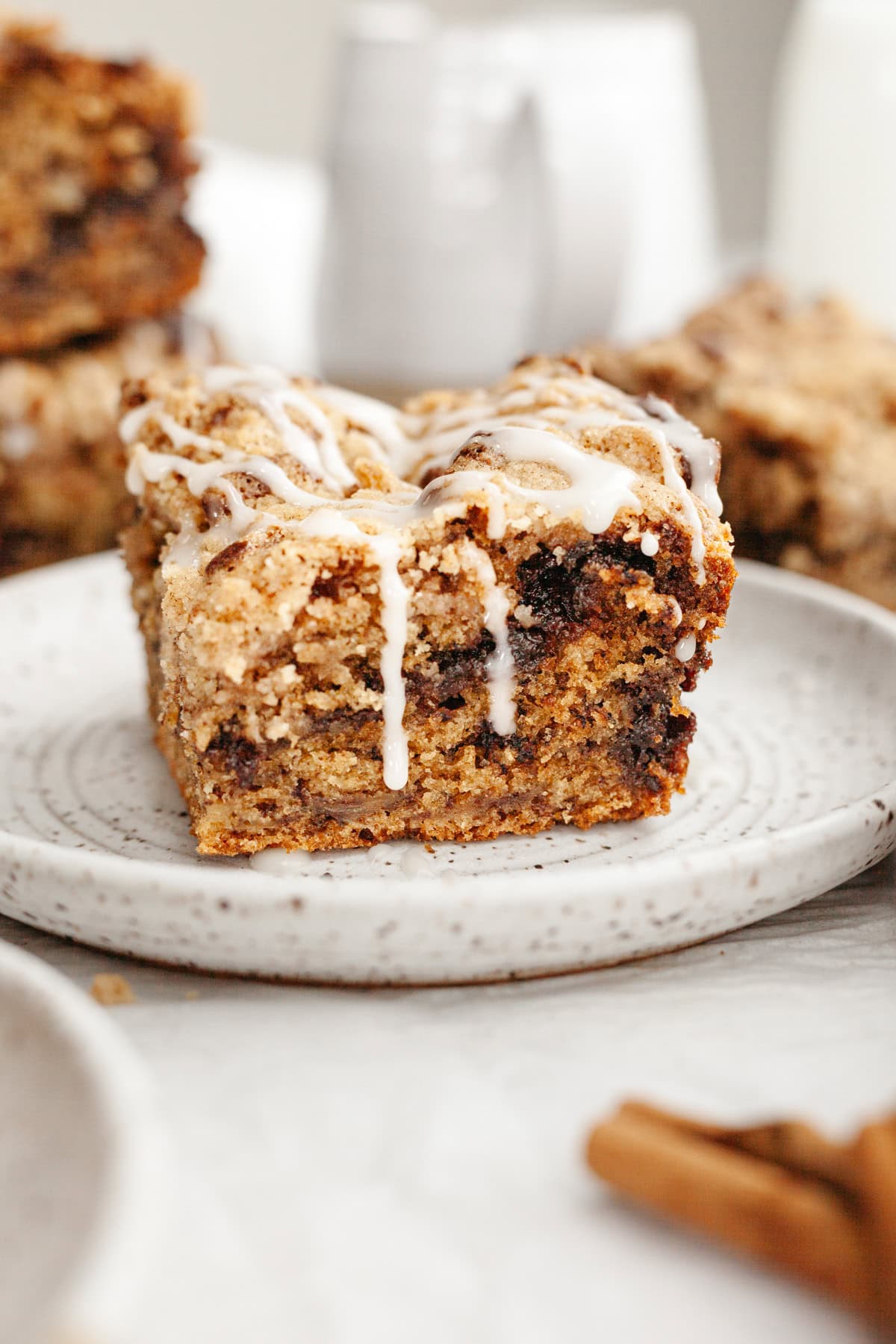 A slice of banana bread coffee cake drizzled with a white glaze on a small plate.