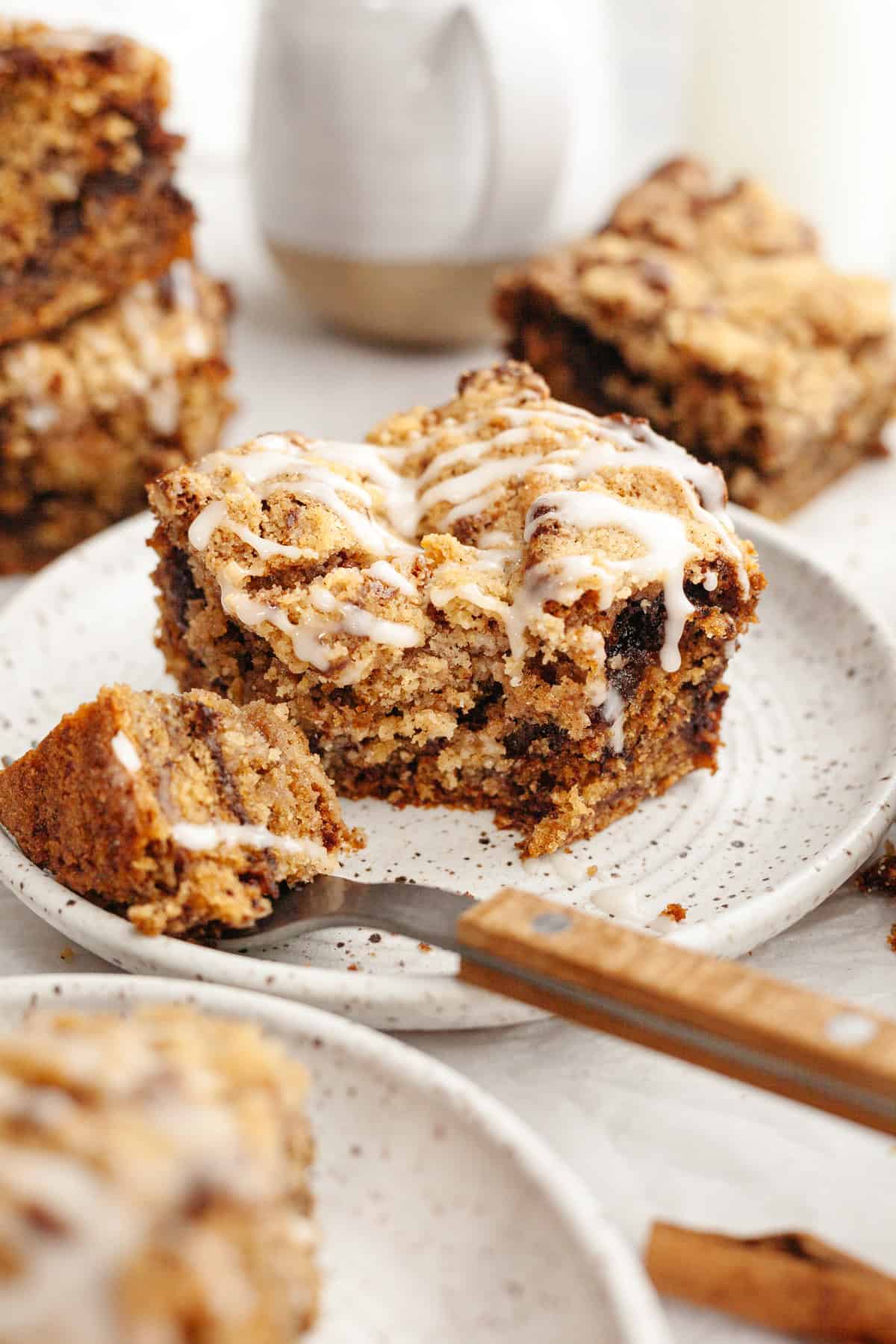 A slice of banana bread coffee cake drizzled with a white glaze on a small plate.