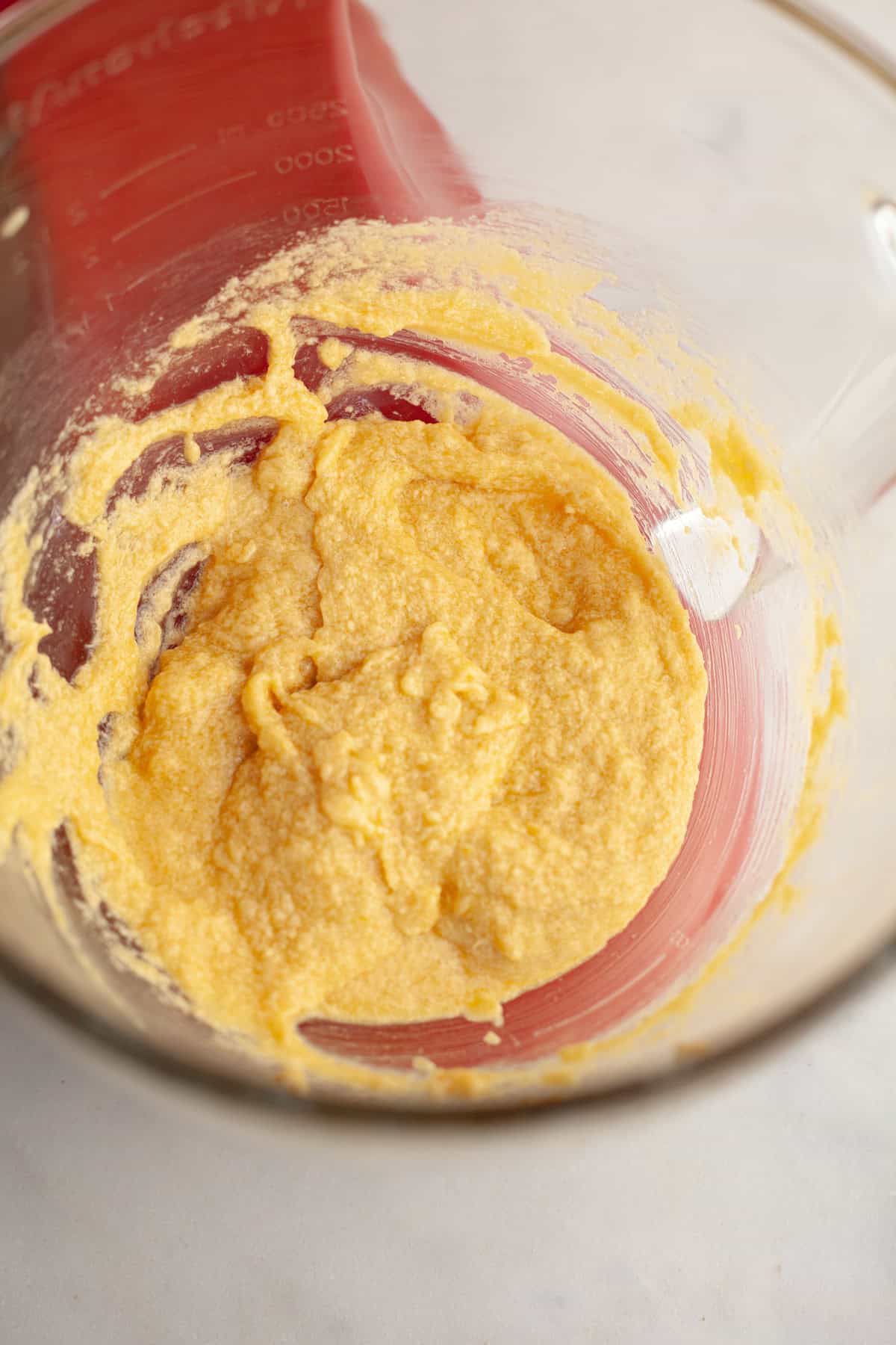 Creamed butter, sugar, and eggs in a glass bowl.
