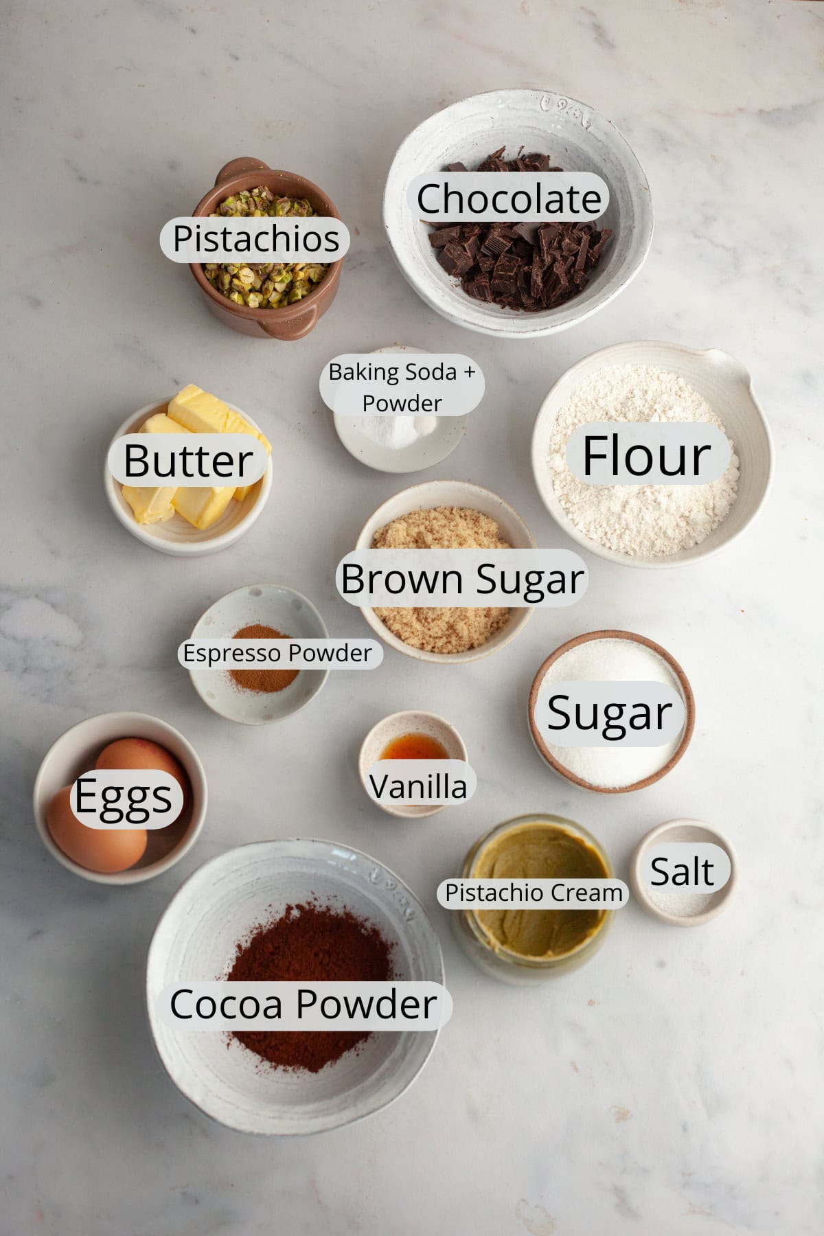 All the ingredients needed to make chocolate pistachio stuffed cookies, weighed out into small bowls.
