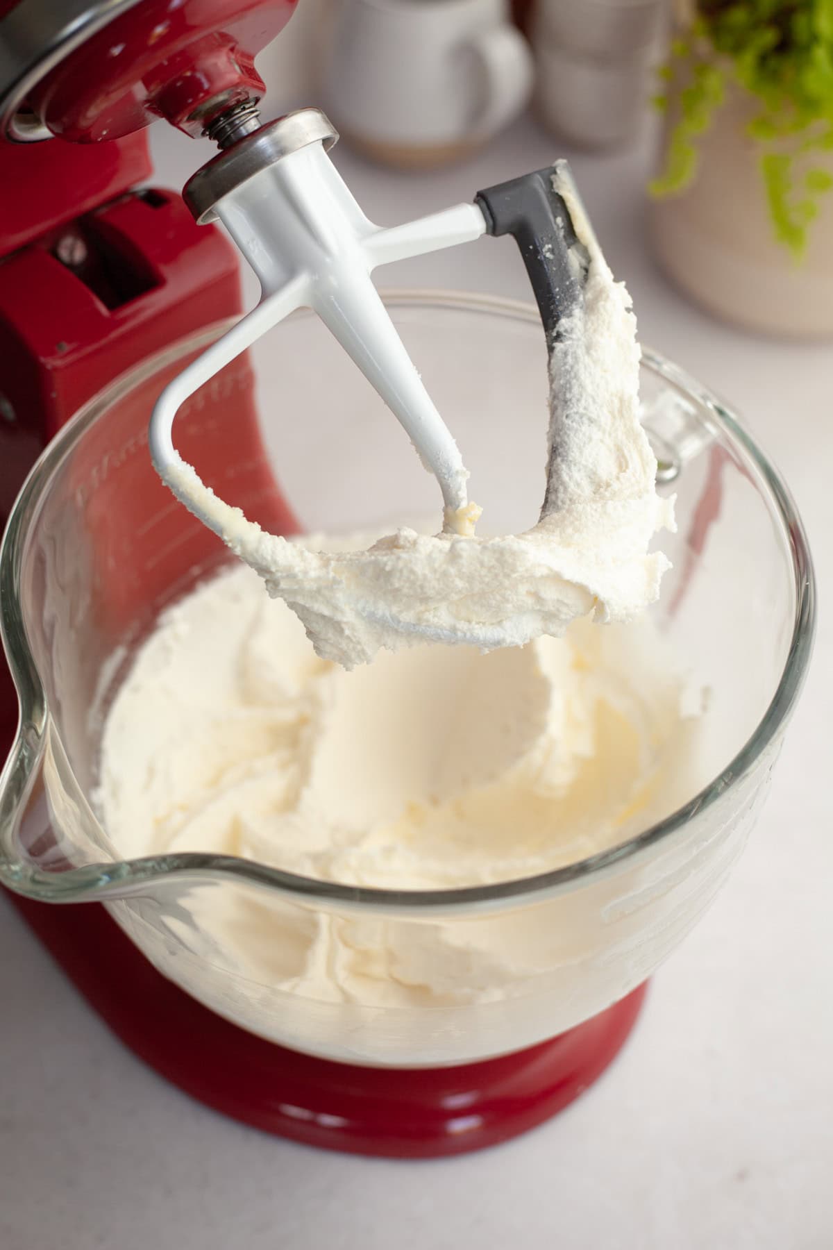 Whipped butter and sugar in a red stand mixer.