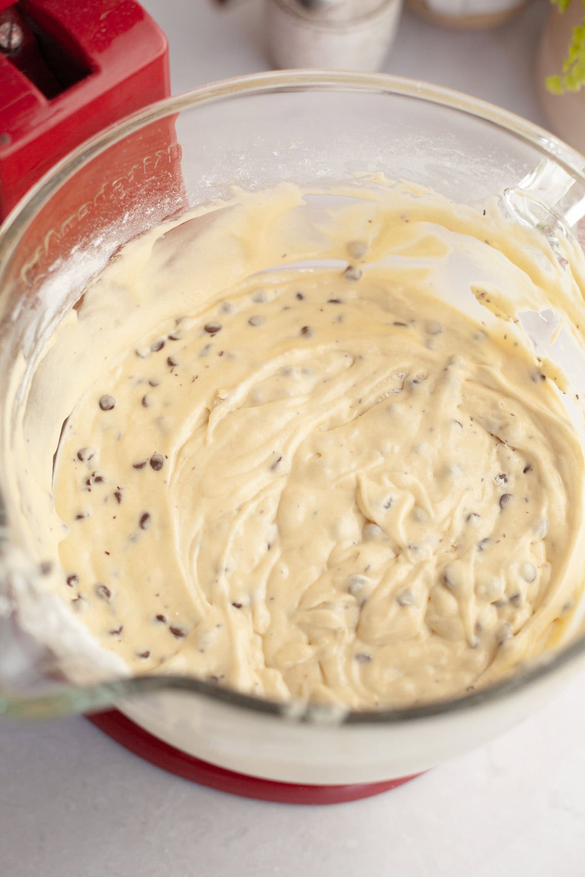 Chocolate chip cake batter in a glass mixing bowl.