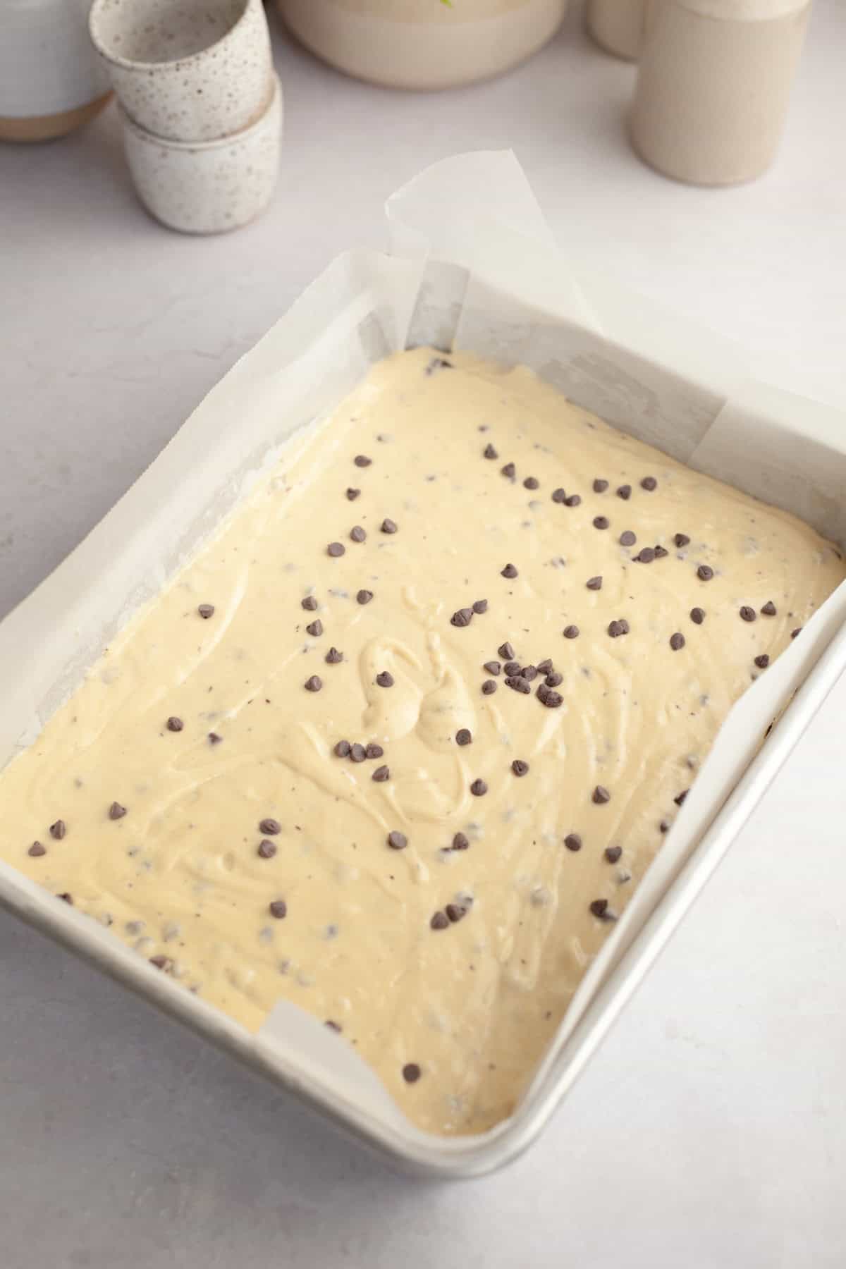 Unbaked chocolate chip sheet cake in a large 9x13-inch baking pan.