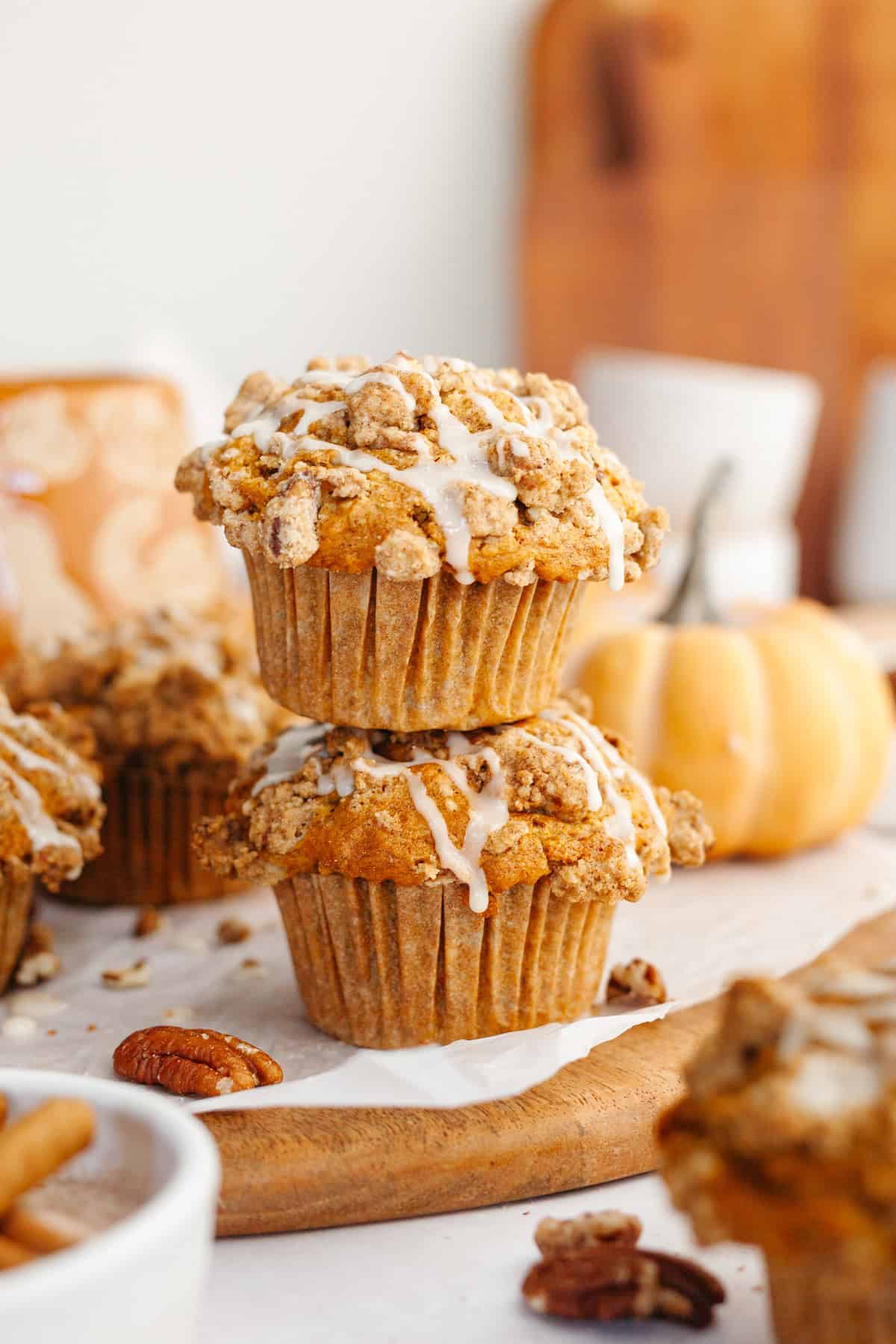 A stack of two pecan pumpkin muffins on a wooden board.