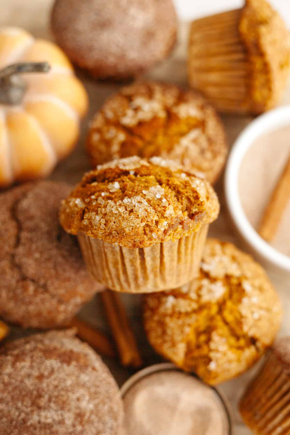 A close up of pumpkin muffins on parchment paper.