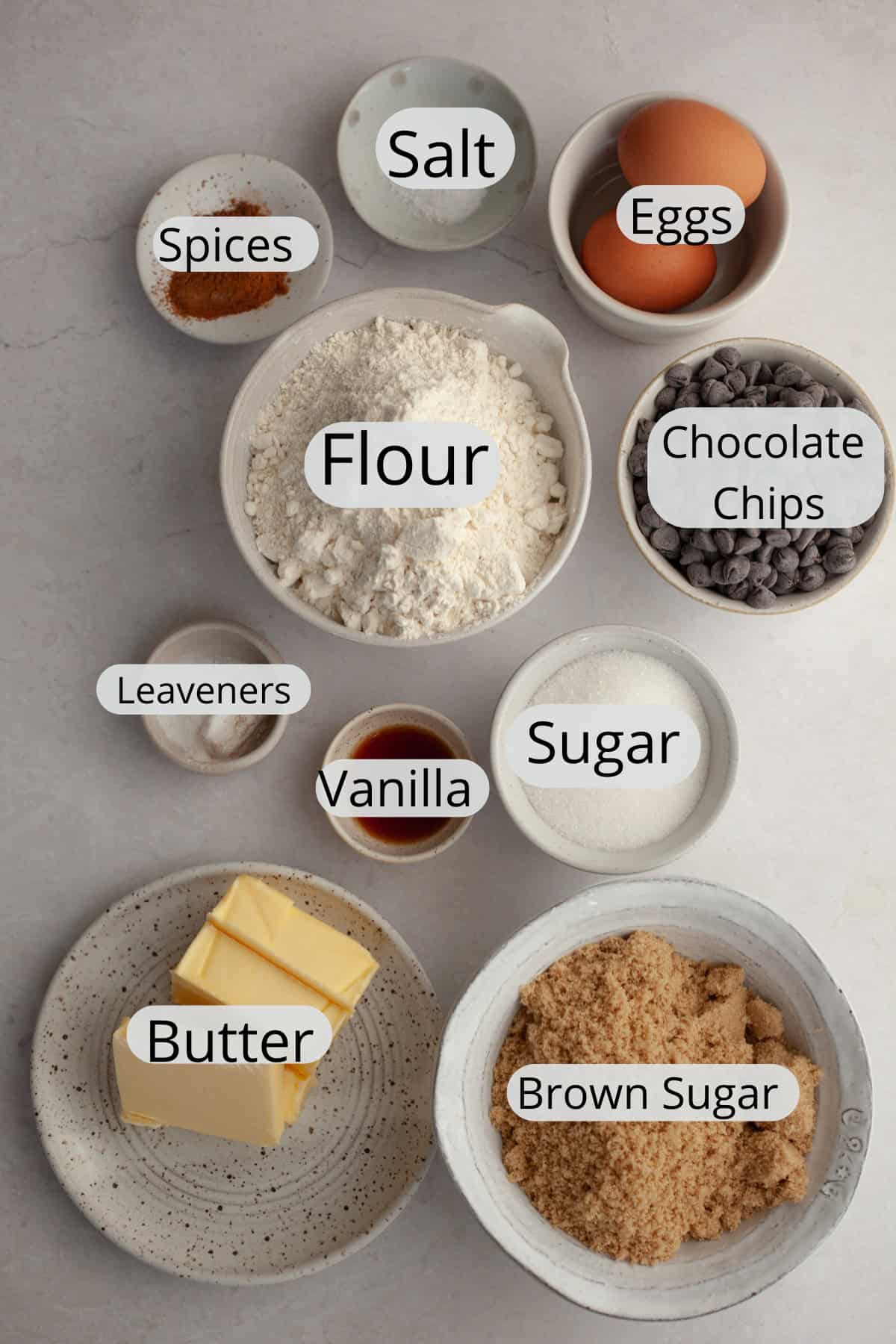 All the ingredients needed to make brown butter chocolate chip cinnamon cookies, weighed out into small bowls.