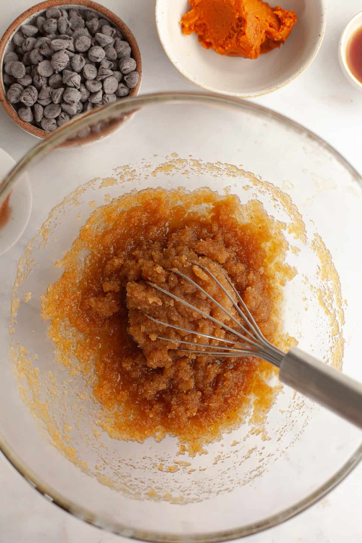 Melted butter and sugar in a glass bowl with a whisk.