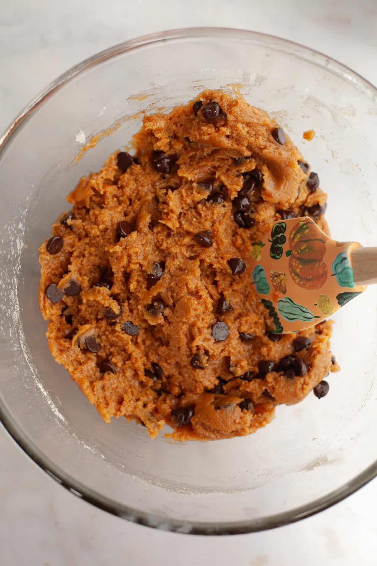 Pumpkin chocolate chip cookie dough in a glass bowl.
