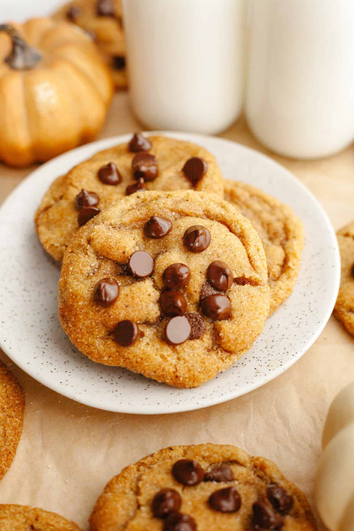 Three browned butter pumpkin chocolate chip cookies on a small plate.