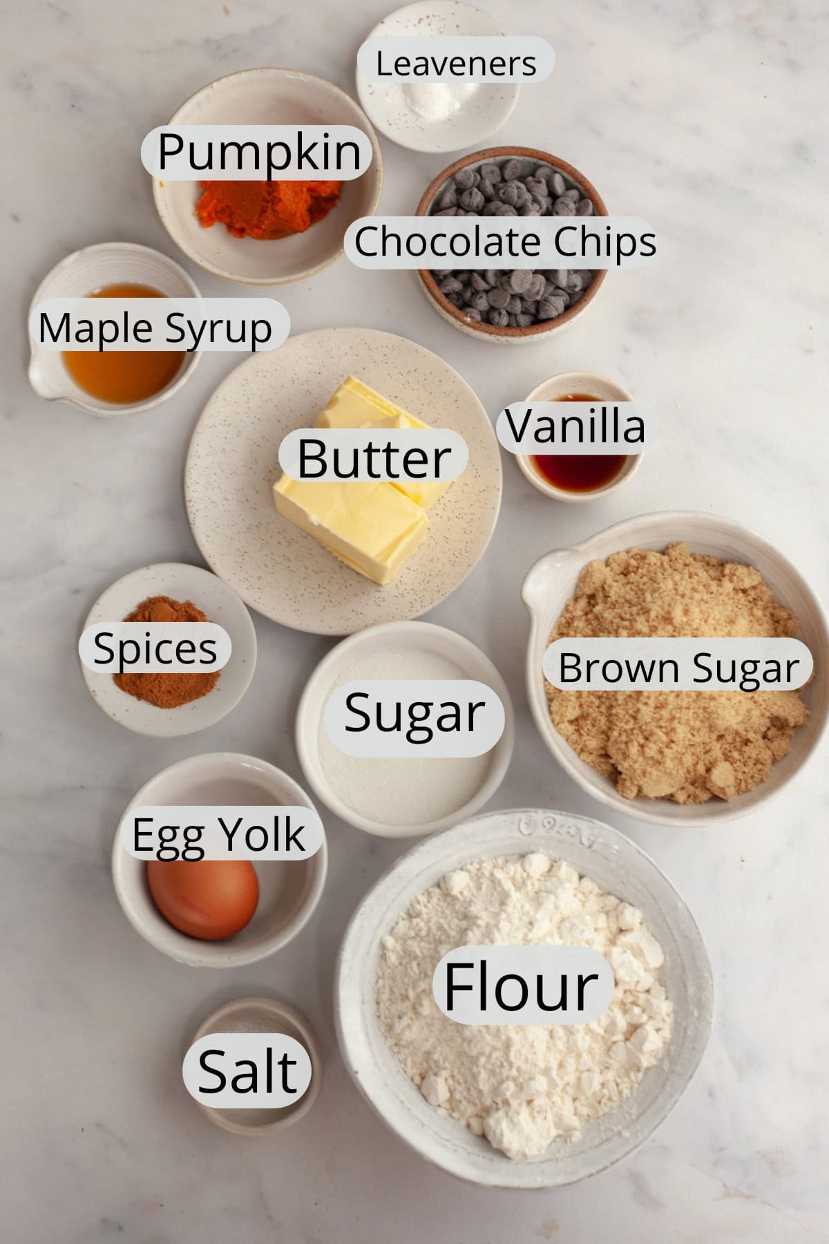 All the ingredients needed for brown butter pumpkin chocolate chip cookies, weighed out into small bowls.