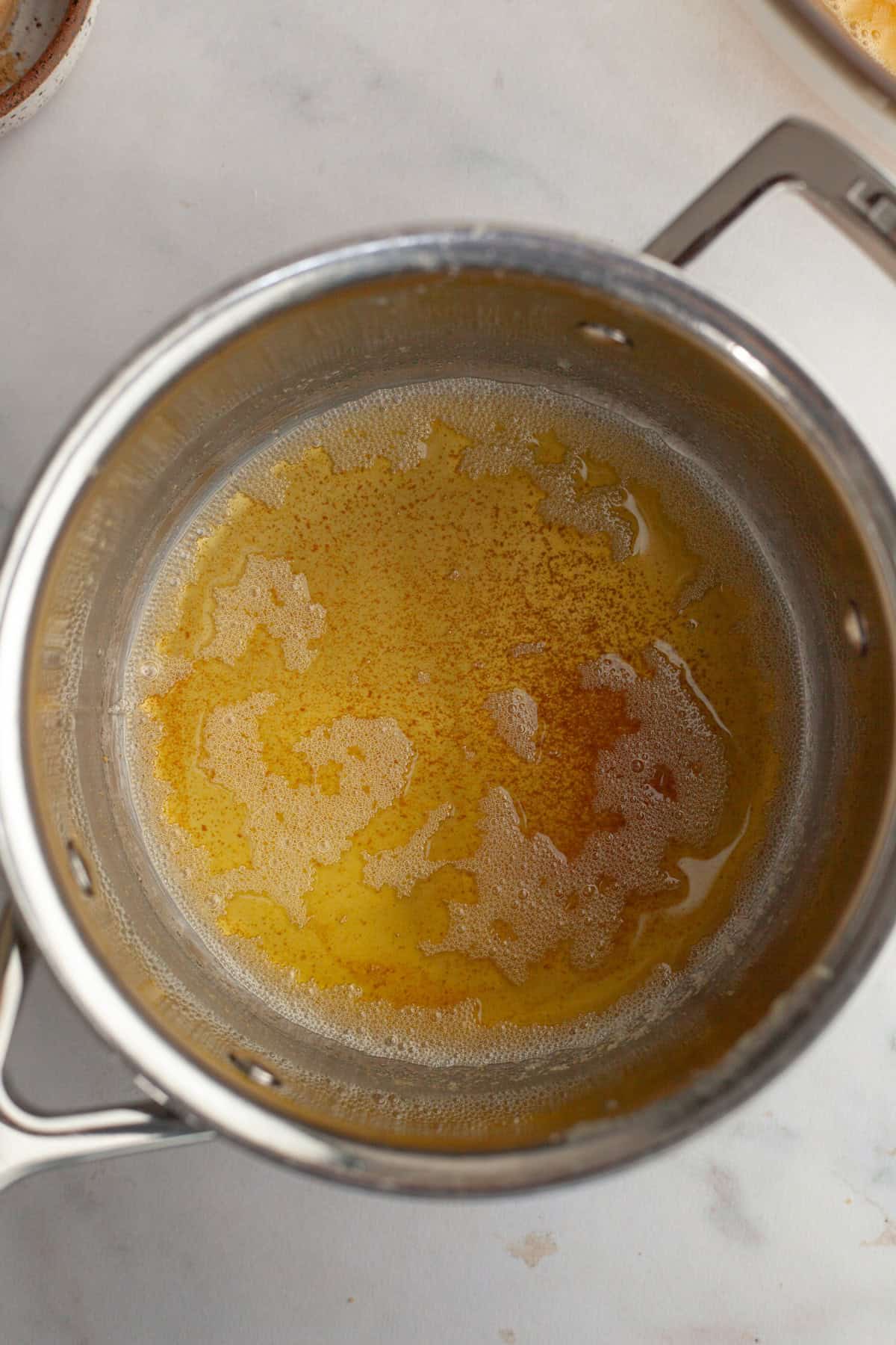 A small saucepan with brown butter in it.