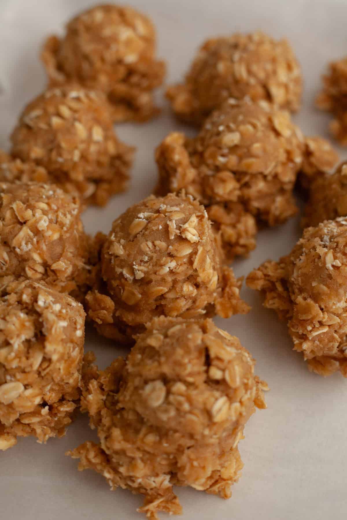 Oatmeal cookie dough balls on parchment paper.