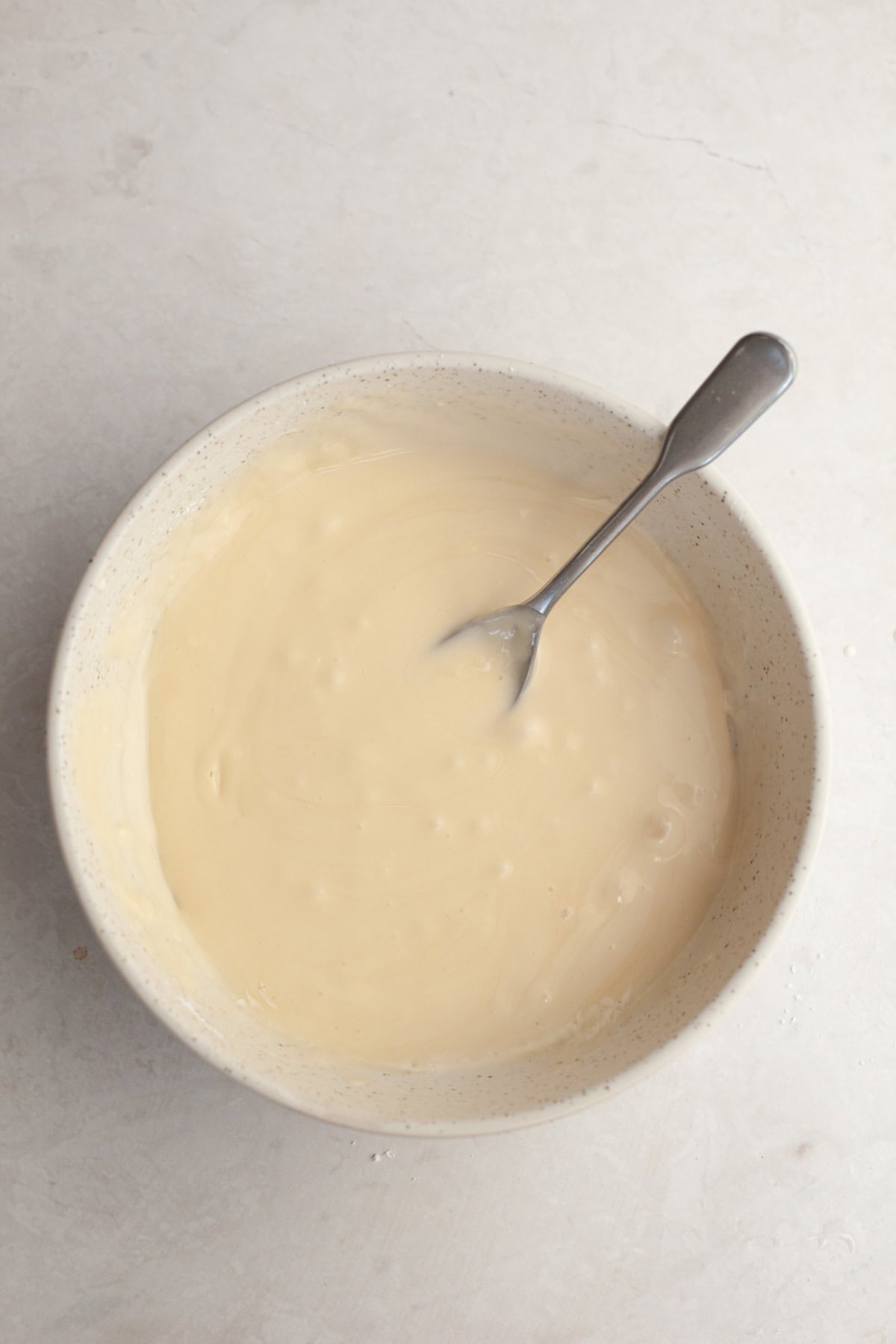 Maple espresso glaze in a small white bowl with a spoon.