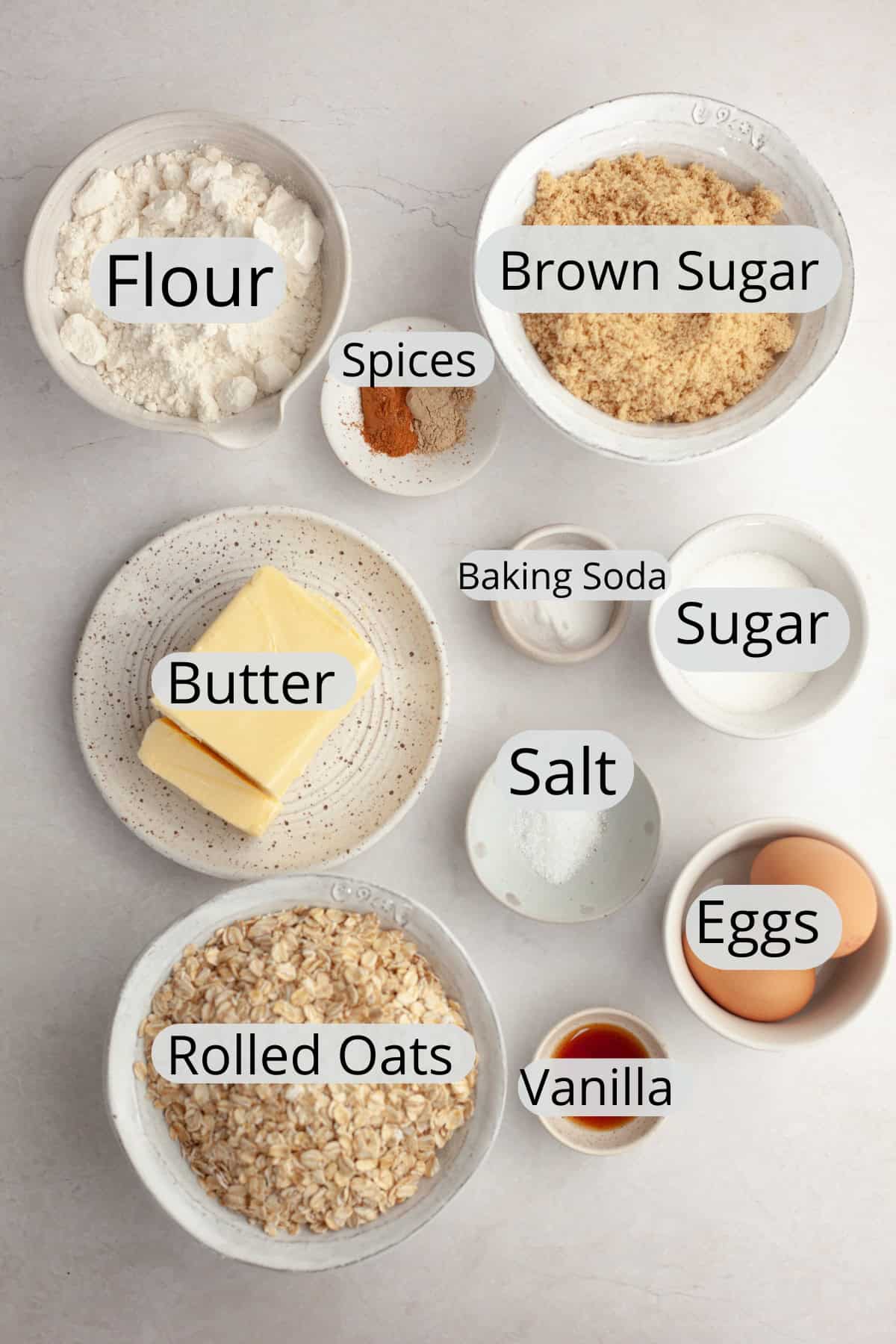 All the ingredients needed to make glazed cardamom oatmeal cookies, weighed out into small bowls.