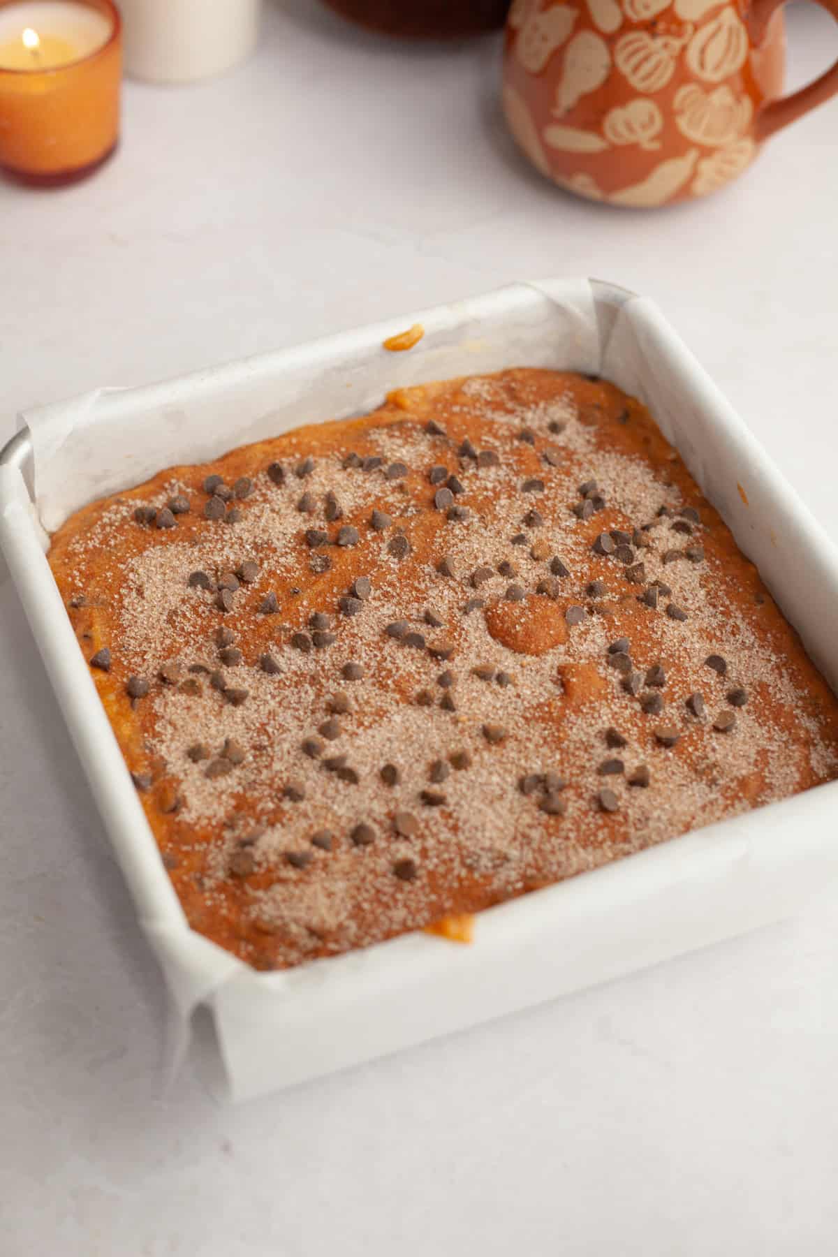 Unbaked pumpkin chocolate chip cake in a square pan.