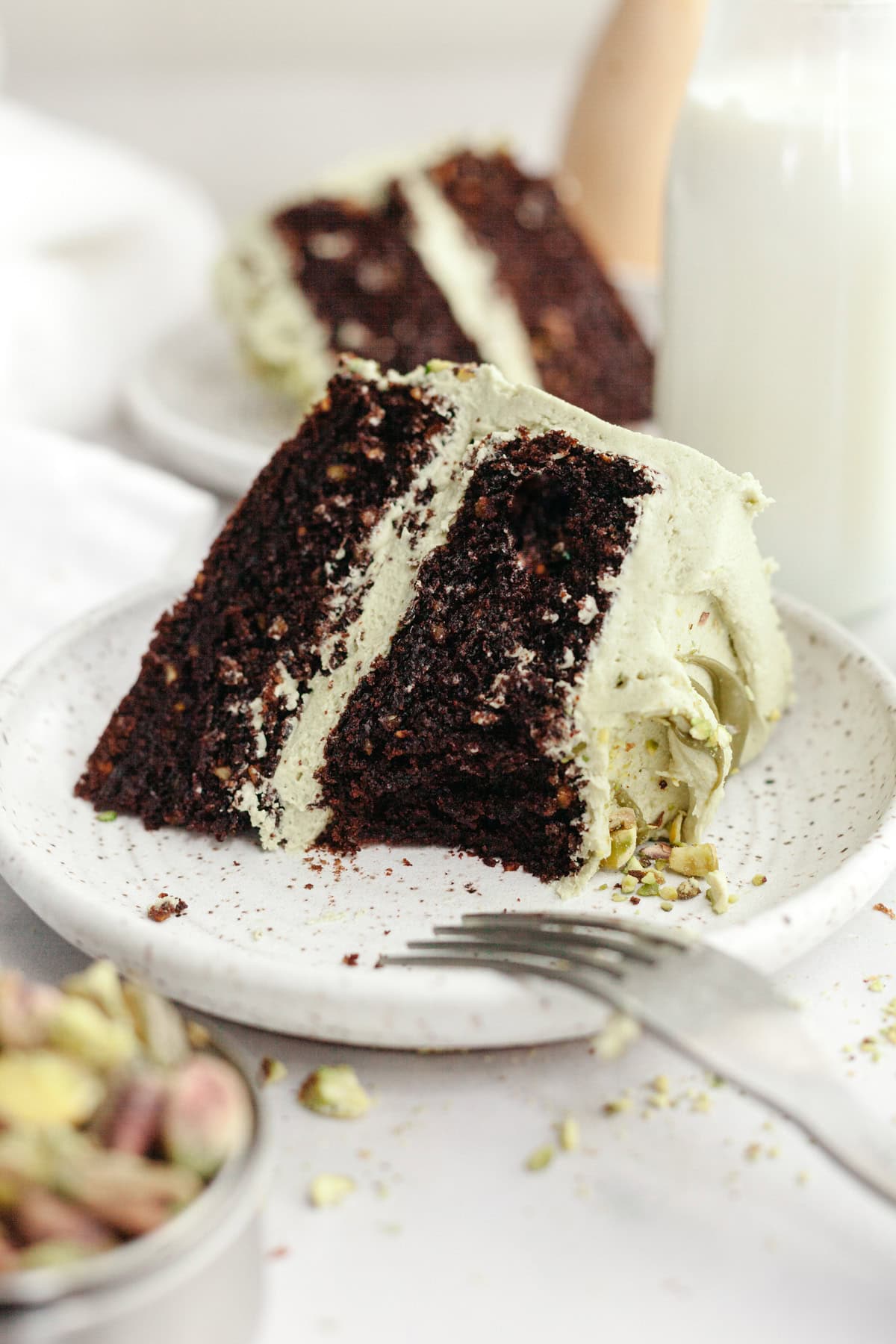 A slice of pistachio chocolate cake on a small plate.