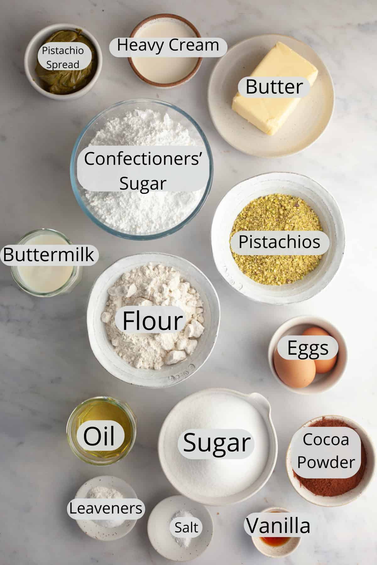 All the ingredients needed to make pistachio chocolate cake, weighed out into small bowls.