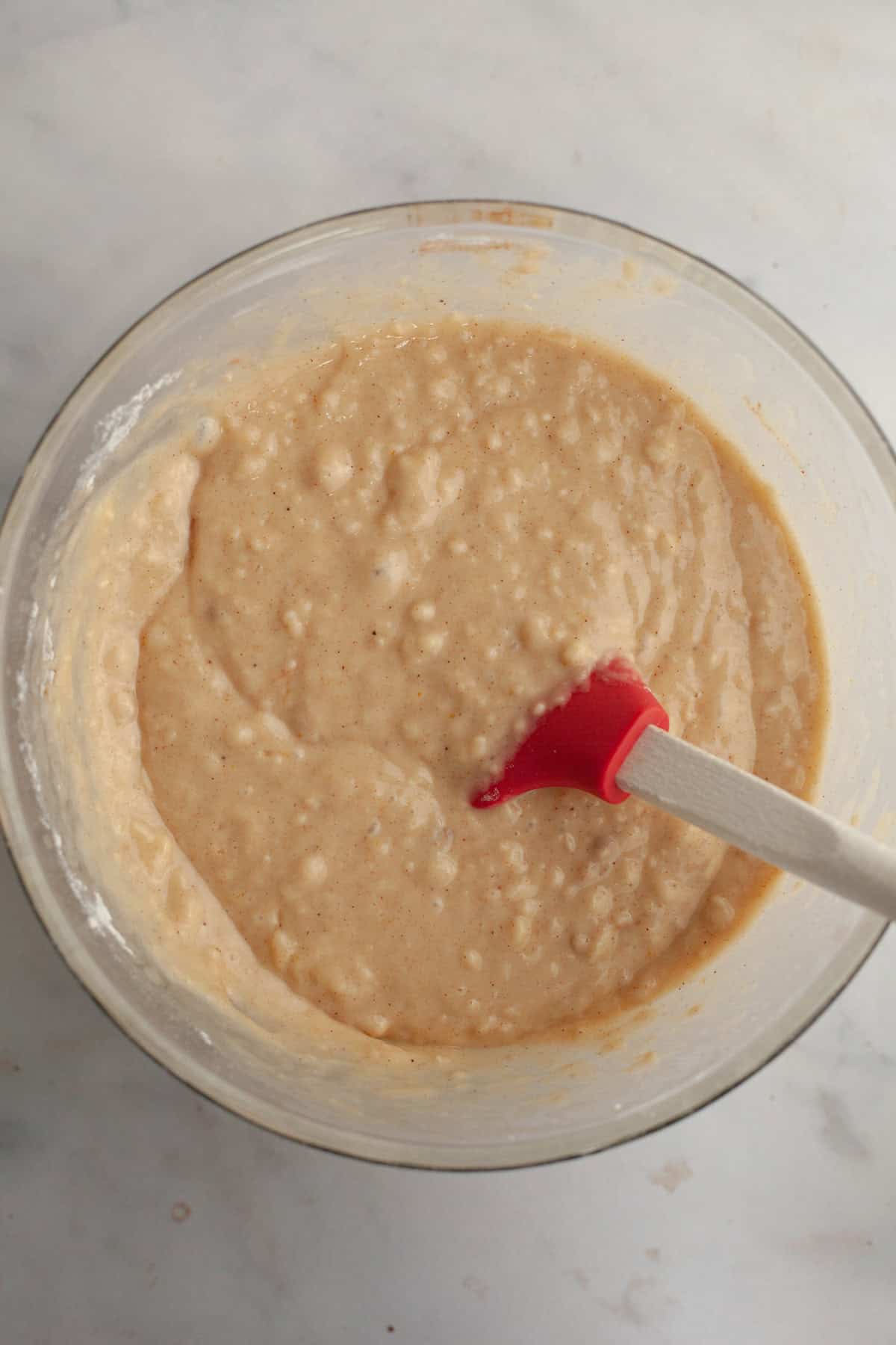 Cinnamon muffin batter in a glass bowl.