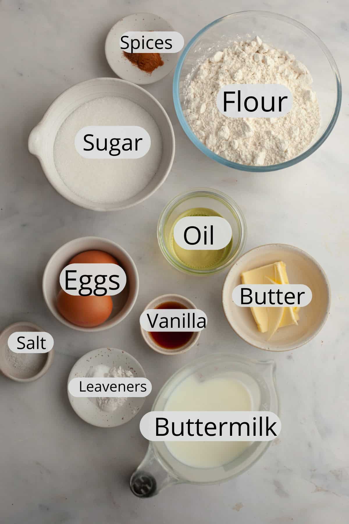All the ingredients needed to make cinnamon mini muffins, weighed out into small bowls.