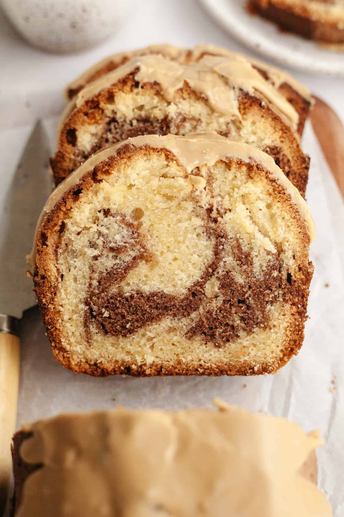 Slices of cinnamon loaf cake on parchment paper.