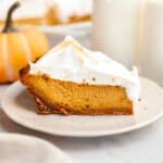 A slice of pumpkin pie with marshmallow topping on a small plate.