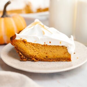 A slice of pumpkin pie with marshmallow topping on a small plate.