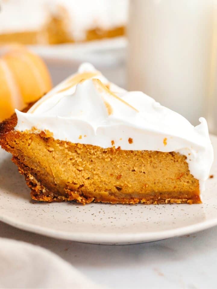 A slice of pumpkin pie with marshmallow topping on a small plate.
