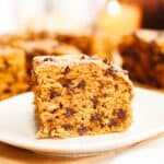 A close up of a square slice of pumpkin chocolate chip cake on a small plate.