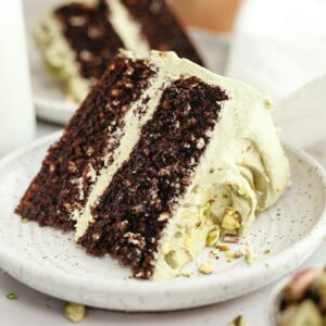 A slice of pistachio chocolate cake on a small plate.